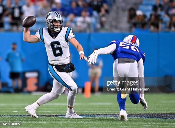 Baker Mayfield of the Carolina Panthers throws again the rush of Mike Love of the Buffalo Bills during the first quarter of a preseason game at Bank...