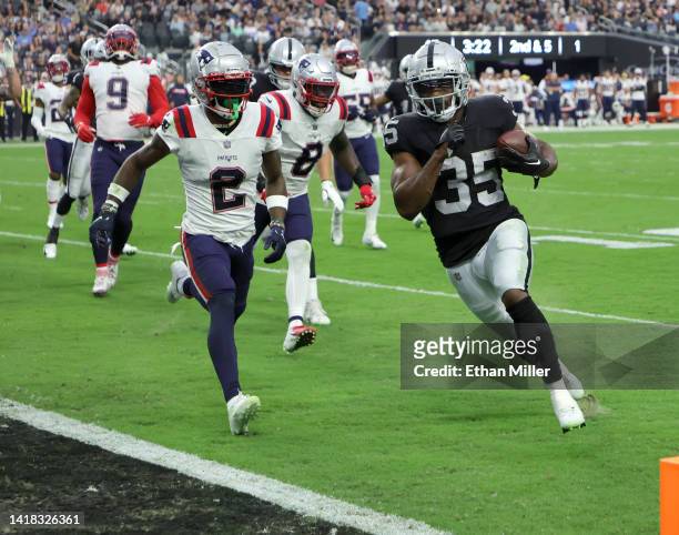 Running back Zamir White of the Las Vegas Raiders runs for a 4-yard touchdown against cornerback Jalen Mills of the New England Patriots during their...