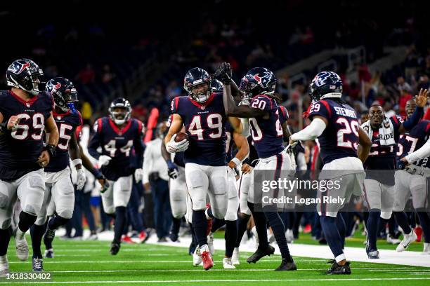 Jake Hansen celebrates with Isaac Yiadom of the Houston Texans and the rest of the team after intercepting a pass in the fourth quarter during a...