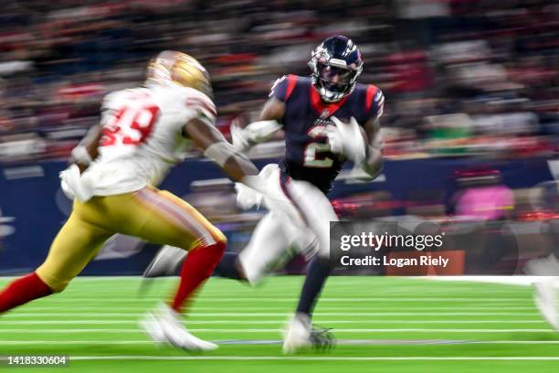 Marlon Mack of the Houston Texans runs past Segun Olubi of the San Francisco 49ers during a preseason game at NRG Stadium on August 25, 2022 in...