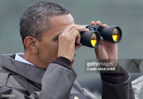 President Barack Obama looks through binoculars towards North Korea from Observation Post Ouellette during a visit to the Joint Security Area of the...