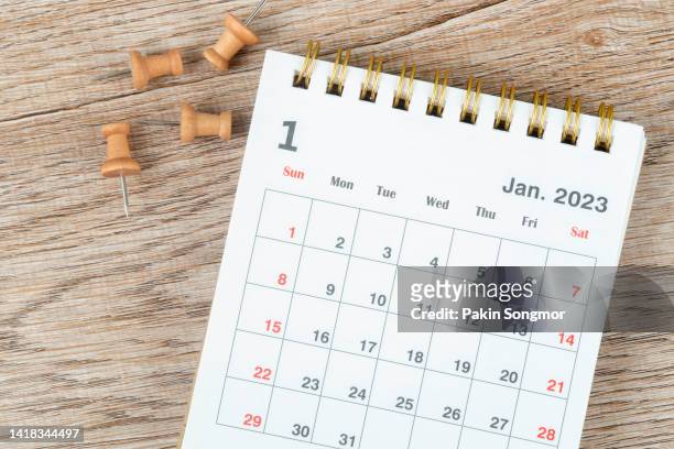 calendar desk 2023 january is the month for the organizer to plan and deadline with a push pin on a wooden background. - calendrier photos et images de collection