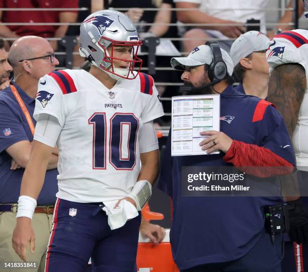 Quarterback Mac Jones and senior football advisor Matt Patricia of the New England Patriots talk on a sideline during their preseason game against...