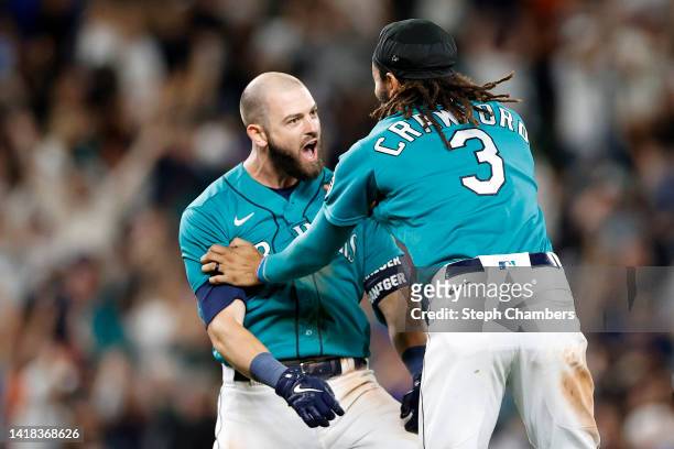 Mitch Haniger of the Seattle Mariners celebrates his walk-off single with J.P. Crawford to score Dylan Moore during the eleventh inning against the...