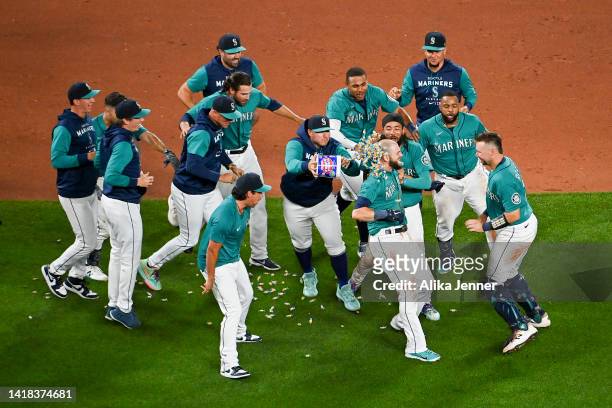 Mitch Haniger of the Seattle Mariners celebrates with teammates after his walk-off single to end the game against the Cleveland Guardians at T-Mobile...