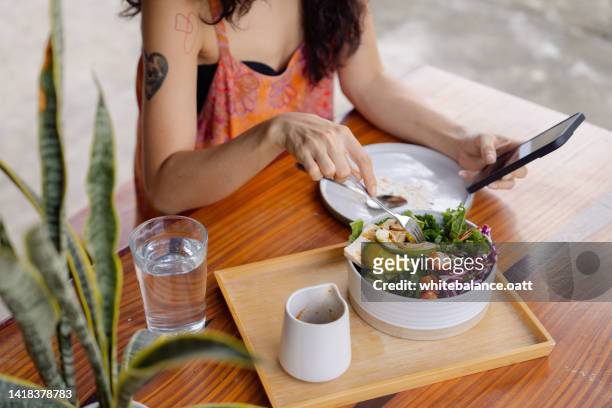 healthy woman having vegan lunch while working at home. - veganisme stock pictures, royalty-free photos & images