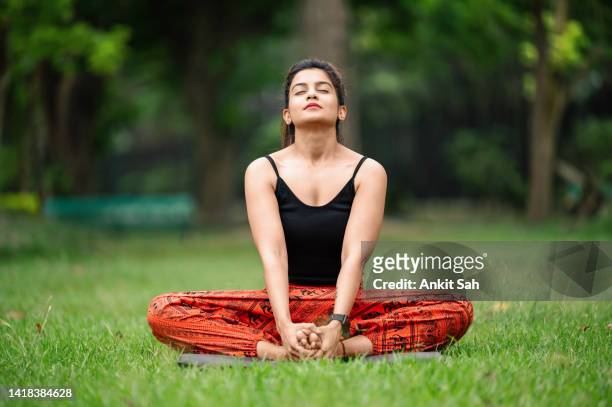 donna seduta in posizione di farfalla a piedi nudi al parco - indian female feet foto e immagini stock