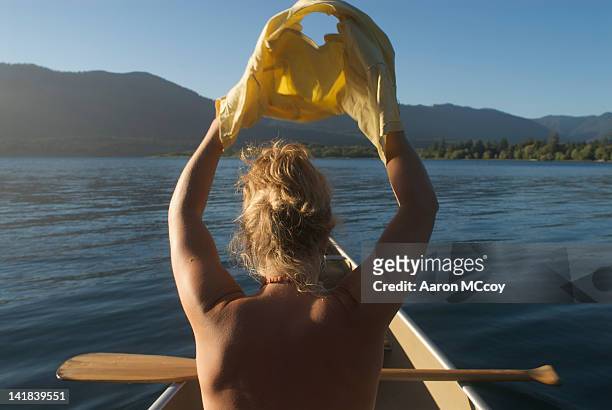 woman taking off shirt on lake quinault, olympic national park, washington state - abbigliamento intimo foto e immagini stock