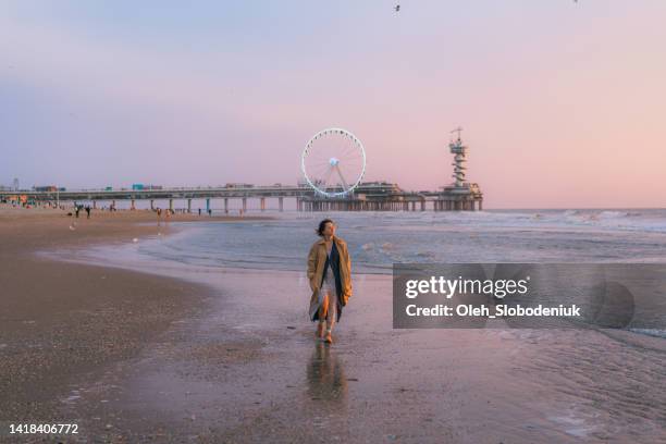 woman walking on the beach in the hague - the hague summer stock pictures, royalty-free photos & images