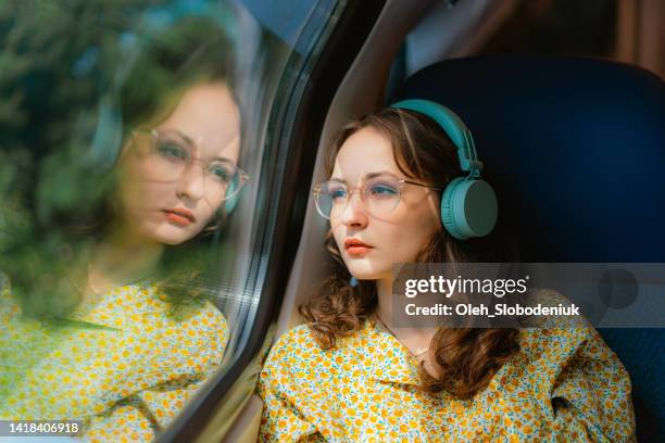 mujer escuchando música con auriculares mientras viaja en el tren - trein nederland fotografías e imágenes de stock