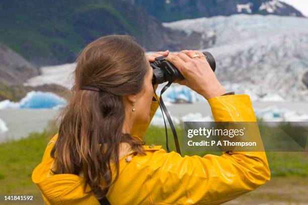 woman looking through binoculars, mendenhall glacier, juneau, alaska, usa - woman looking through ice stock pictures, royalty-free photos & images