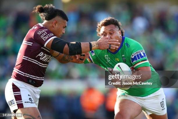 Josh Papalii of the Raiders is tackled by Haumole Olakau'atu of the Sea Eagles during the round 24 NRL match between the Canberra Raiders and the...