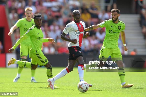 Moussa Djenepo of Southampton is challenged by Anthony Elanga and Bruno Fernandes of Manchester United during the Premier League match between...
