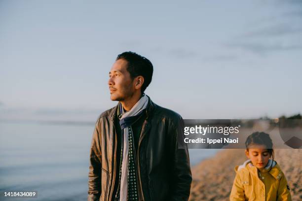 father contemplating on beach at sunset, australia - mann bart portrait mit kind stock-fotos und bilder