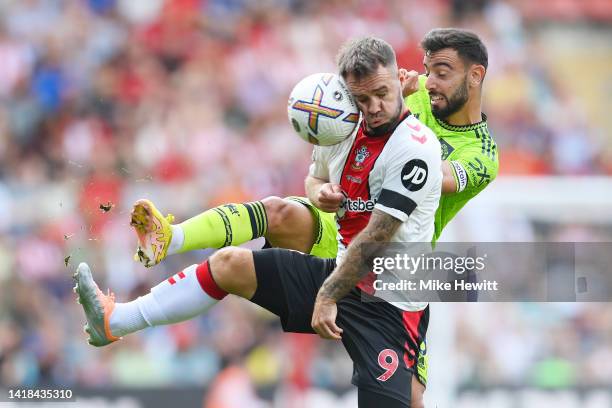 Adam Armstrong of Southampton is challenged by Bruno Fernandes of Manchester United during the Premier League match between Southampton FC and...