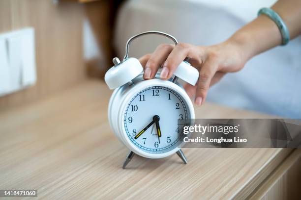 a woman's hand pressed the alarm clock - alarm clock close up stock pictures, royalty-free photos & images