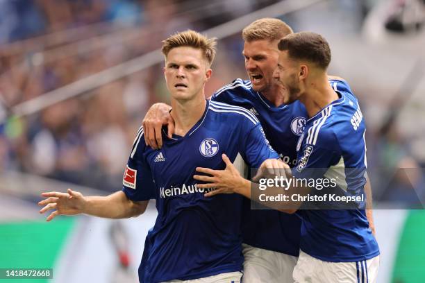 Marius Bulter of FC Schalke 04 celebrates with teammates after scoring their team's first goal from the penalty spot during the Bundesliga match...