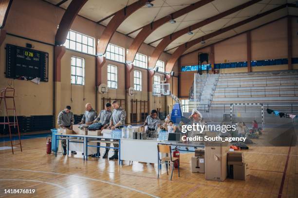 soldiers preparing donations for civilians - school gymnasium stock pictures, royalty-free photos & images