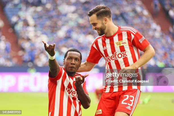 Sheraldo Becker of FC Union Berlin celebrates with teammate Niko Giebelmann after scoring their team's fourth goal during the Bundesliga match...