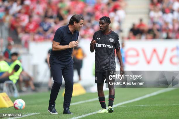 Gerardo Seoane, Manager of Bayer Leverkusen, interacts with Jeremie Frimpong of Bayer Leverkusen during the Bundesliga match between 1. FSV Mainz 05...