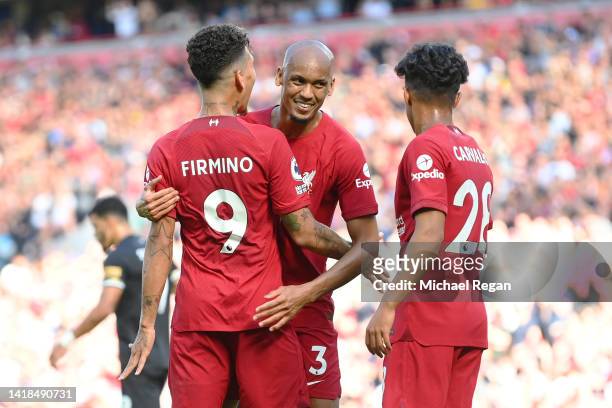 Roberto Firmino of Liverpool celebrates with teammates Fabinho and Fabio Carvalho after scoring their team's seventh goal during the Premier League...
