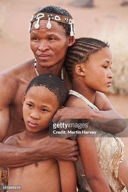 indigenous bushman/san family embracing (10 years old, 14 years old, 43 years old), namibia (image taken to raise awareness and funds for the conservation projects of n/ - 14 15 years stockfoto's en -beelden