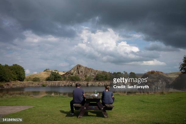 Couple sit at Cawfields quarry on Hadrian's Wall on August 27, 2022 in Hexham, United Kingdom. 2022 is the 1900 anniversary of the building of the...