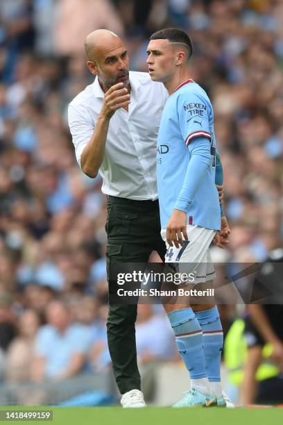 Pep Guardiola, Manager of Manchester City interacts with Phil Foden of Manchester City during the Premier League match between Manchester City and...