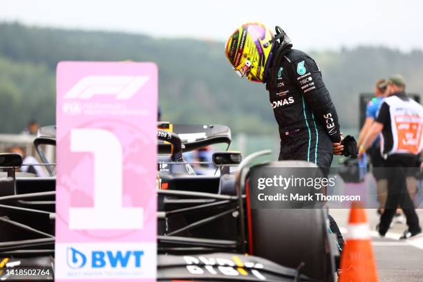 7th place qualifier Lewis Hamilton of Great Britain and Mercedes inspects the car of Max Verstappen of the Netherlands and Oracle Red Bull Racing in...