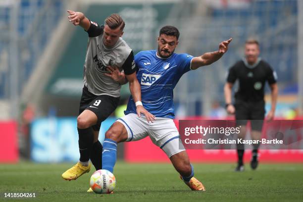 Ozan Kabak of TSG 1899 Hoffenheim challenges Ermedin Demirovic of FC Augsburg during the Bundesliga match between TSG Hoffenheim and FC Augsburg at...