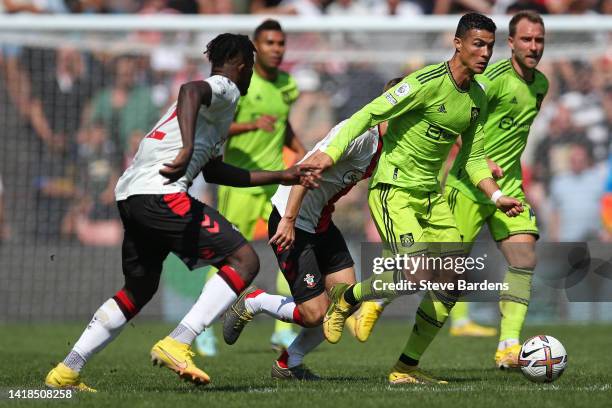 Cristiano Ronaldo of Manchester United is challenged by James Ward-Prowse of Southampton during the Premier League match between Southampton FC and...