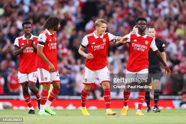 Martin Odegaard of Arsenal celebrates their sides first goal with team mate Bukayo Saka during the Premier League match between Arsenal FC and Fulham...