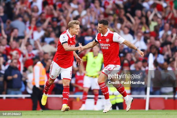 Martin Odegaard of Arsenal celebrates their sides first goal with team mate Granit Xhaka during the Premier League match between Arsenal FC and...