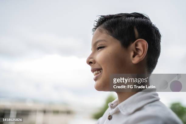 kleiner junge, der nach draußen schaut - hispanic man profile hopeful stock-fotos und bilder