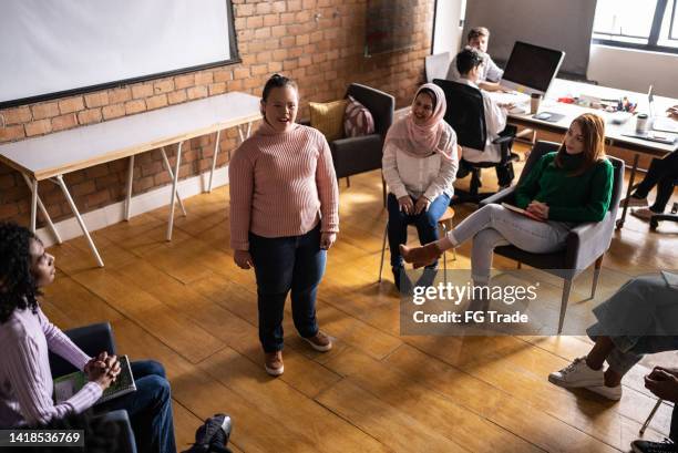 young woman with special needs giving a lecture in an university or group therapy - mental disability stock pictures, royalty-free photos & images