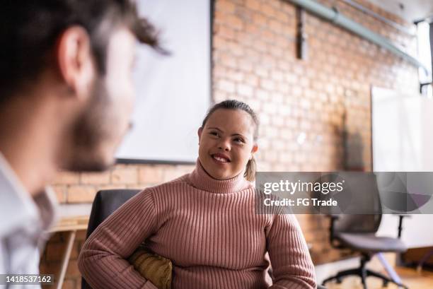 young woman with special needs talking to a colleague in the office - down syndrome stock pictures, royalty-free photos & images