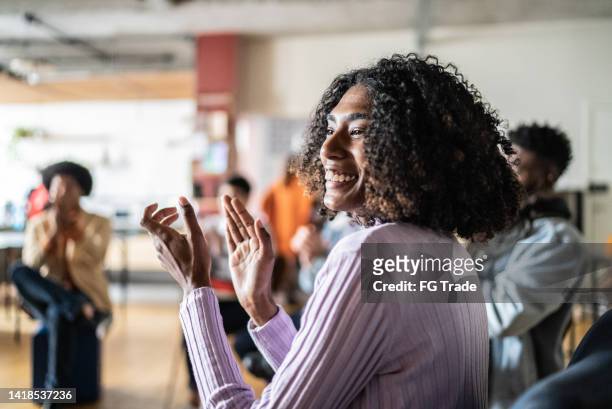 young woman clapping in a seminar or group therapy - meek mill supporters protest on day of status hearing stockfoto's en -beelden