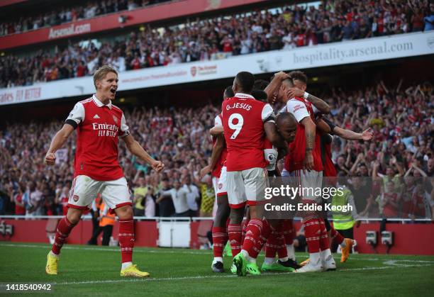 Martin Odegaard of Arsenal celebrates the goal of Gabriel Magalhaes of Arsenal during their sides second goal with team mates during the Premier...