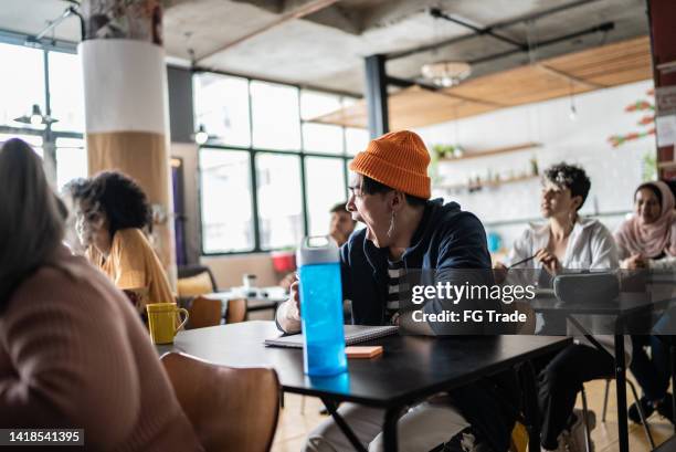 tired young man taking notes during class in the university - bored audience stock pictures, royalty-free photos & images