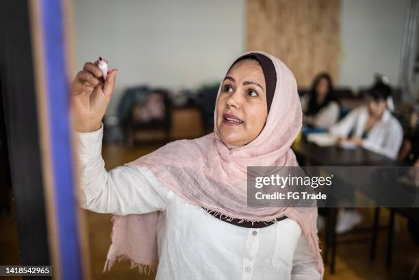 teacher teaching in the classroom - hoofddoek stockfoto's en -beelden