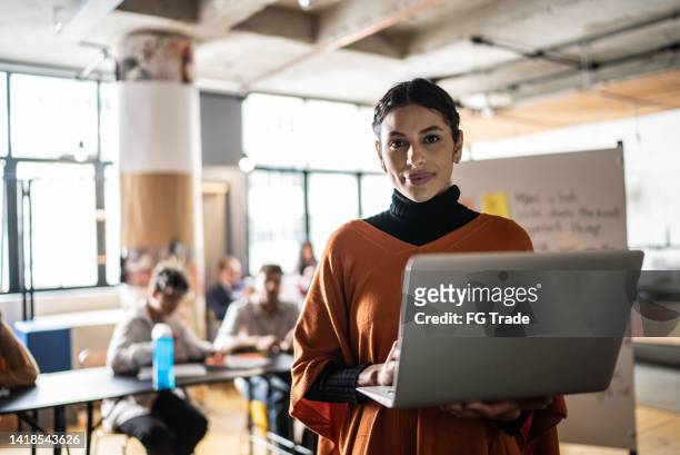 retrato de una mujer joven usando la computadora portátil en el aula - altos cargos directivos fotografías e imágenes de stock