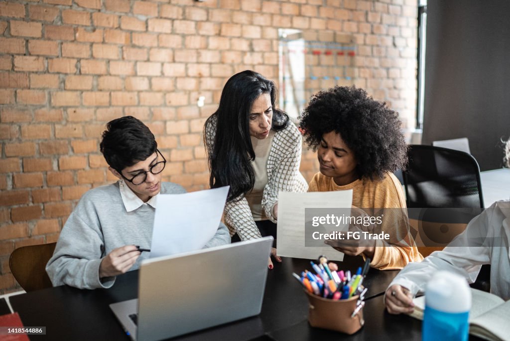 Helping Others In Class Teacher Helping Students During Class In The University High-Res Stock ...
