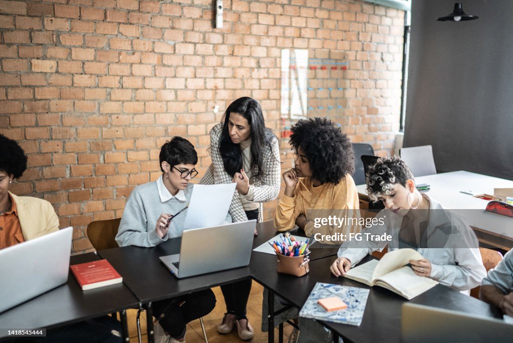 Helping Others In Class Teacher Helping Students During Class In The University High-Res Stock ...