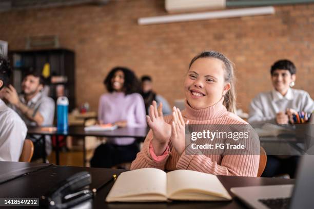 young woman with special needs clapping in the classroom - developmental disability 個照片及圖片檔