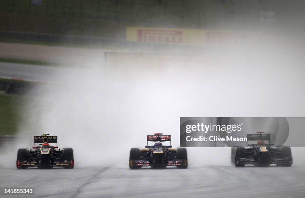 Romain Grosjean of France and Lotus, Daniel Ricciardo of Australia and Scuderia Toro Rosso and Heikki Kovalainen of Finland and Caterham drive during...