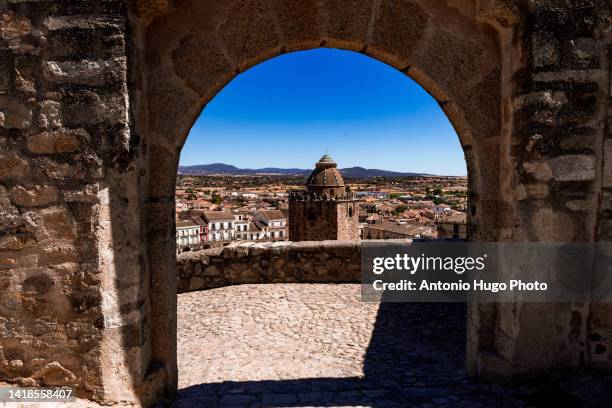 view of a stone arch and the city of trujillo from a lookout point. caceres, extremadura, spain. - trujillo stock-fotos und bilder