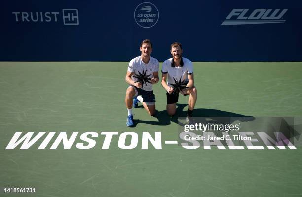 Matthew Ebden of Australia and Jamie Murray of Great Britain pose with the trophy following their victory over Hugo Nys of Monaco and Jan Zielinski...