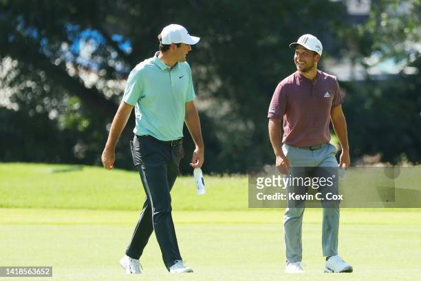Scottie Scheffler of the United States and Xander Schauffele of the United States walk on the first hole during the third round of the TOUR...