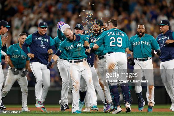 Mitch Haniger of the Seattle Mariners celebrates his walk-off single to score Dylan Moore during the eleventh inning against the Cleveland Guardians...