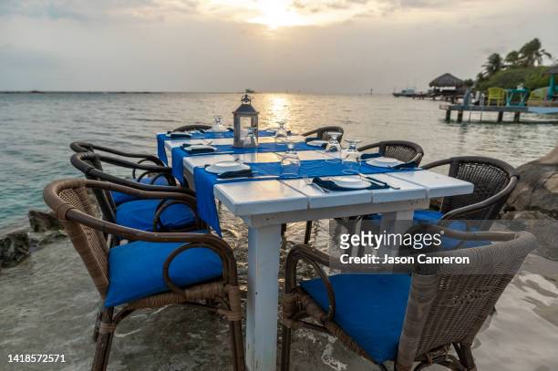 sunset aruba in the ocean dining table low - aruba beach stock-fotos und bilder